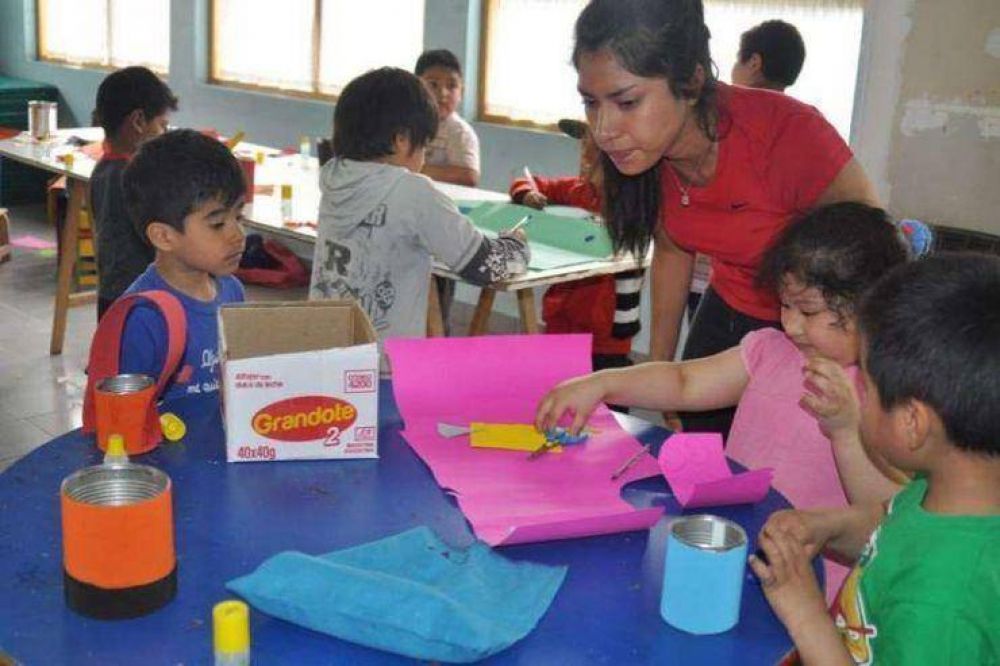 Chicos que participan de las colonias de verano realizan actividades en una biblioteca popular