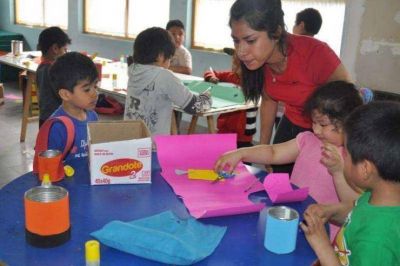 Chicos que participan de las colonias de verano realizan actividades en una biblioteca popular