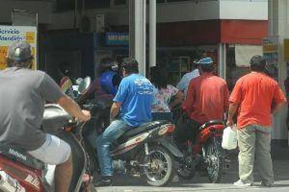 Viveza criolla: motociclistas se prestan casco para comprar nafta