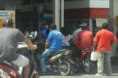 Viveza criolla: motociclistas se prestan casco para comprar nafta