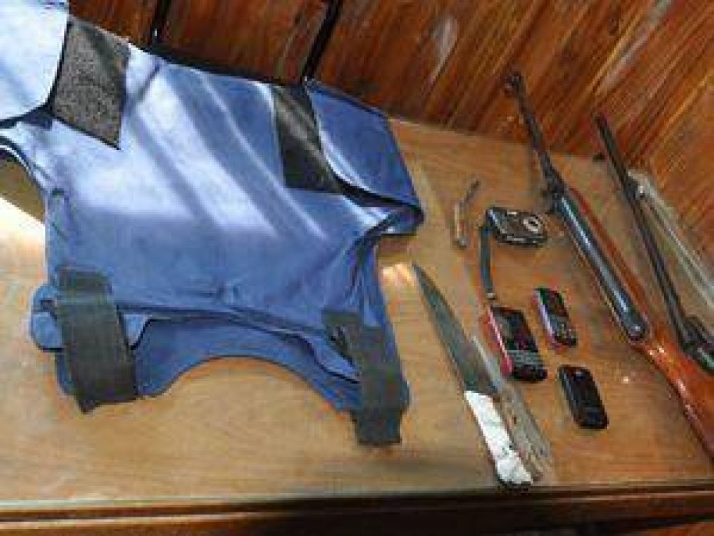Hallan chaleco policial, dos armas y celulares