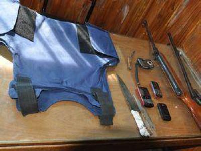 Hallan chaleco policial, dos armas y celulares