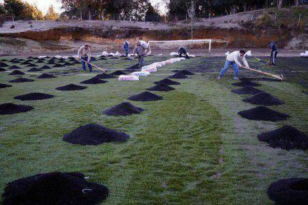 Vecinos colaboran con el personal municipal en la terminaci�n de la cancha de c�sped sint�tico