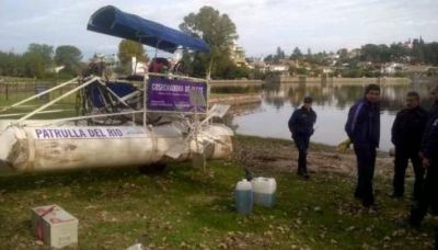 Una cosechadora remueve peces muertos del San Roque