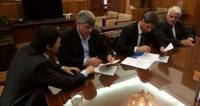 Firman convenio para la finalizaci�n del pago por el excedente v�nico