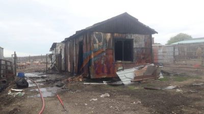 Un galp�n destruido por el fuego ante una quema de basura que se sali� de control