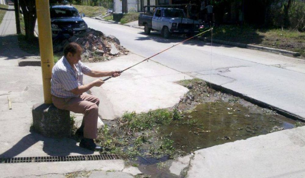 Un tafice�o se puso a "pescar" en un bache del pavimento