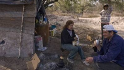 Una familia con dos hijos vive bajo un algarrobo