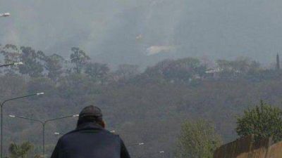 Con la ayuda de aviones hidrantes, tratan de apagar el incendio en el cerro San Javier